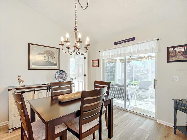 dining space with an inviting chandelier and light hardwood / wood-style flooring