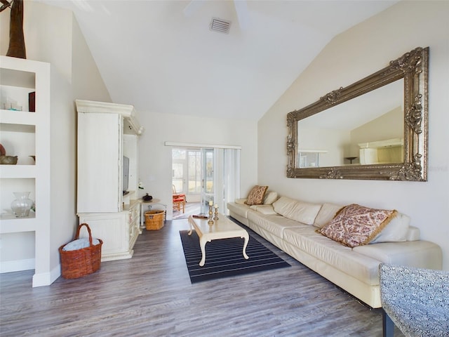 living room featuring dark hardwood / wood-style floors, built in features, and vaulted ceiling