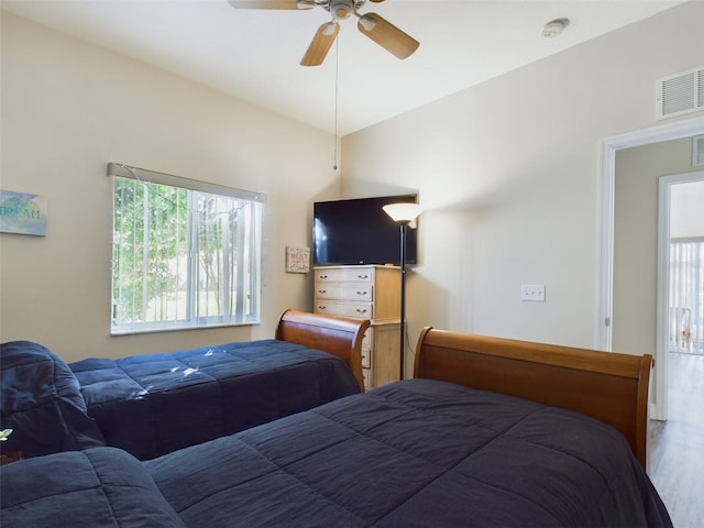 bedroom with ceiling fan, wood-type flooring, and multiple windows