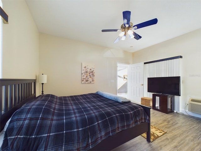 bedroom with hardwood / wood-style floors, an AC wall unit, and ceiling fan