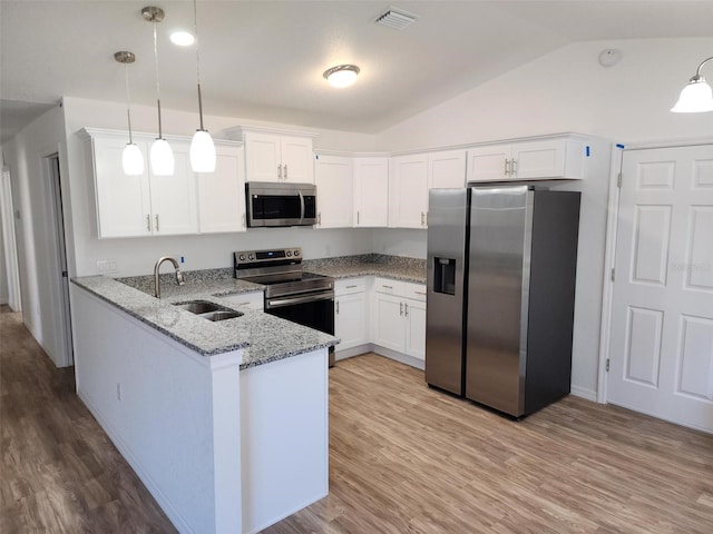 kitchen with lofted ceiling, sink, decorative light fixtures, kitchen peninsula, and stainless steel appliances