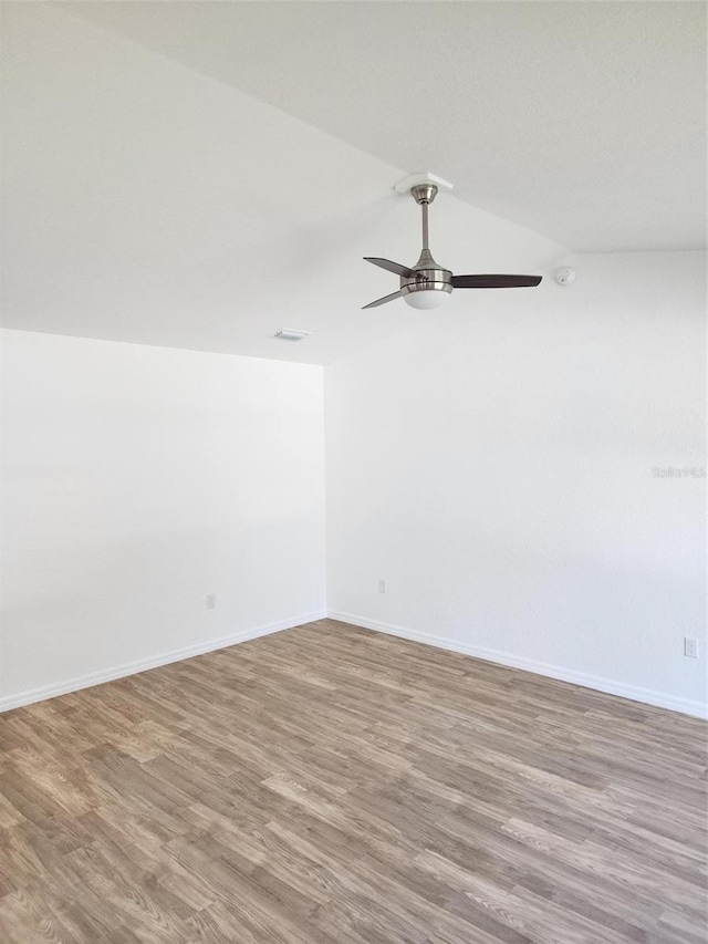 unfurnished room with ceiling fan, wood-type flooring, and lofted ceiling