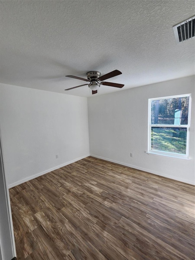 unfurnished room with a textured ceiling, ceiling fan, and dark wood-type flooring