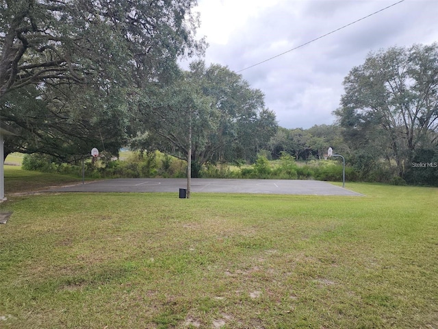 view of yard featuring basketball hoop