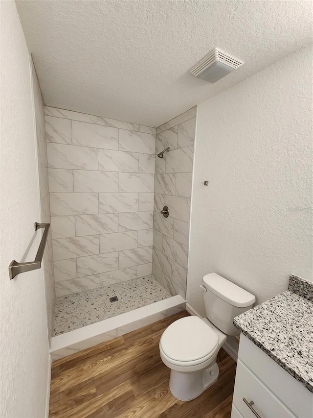 bathroom featuring vanity, hardwood / wood-style floors, a textured ceiling, and toilet