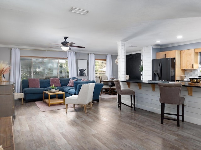 living room with ceiling fan, dark hardwood / wood-style flooring, and ornamental molding