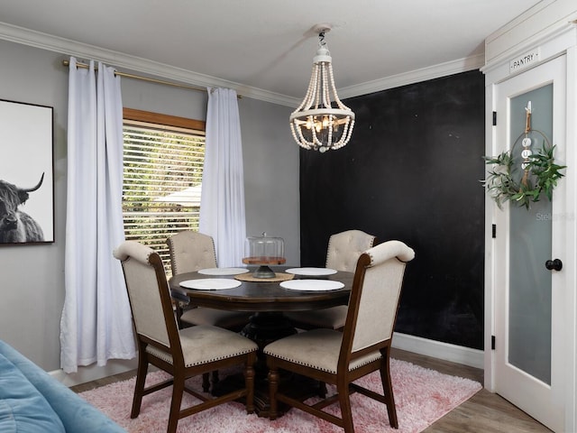 dining area featuring crown molding, hardwood / wood-style flooring, and a chandelier