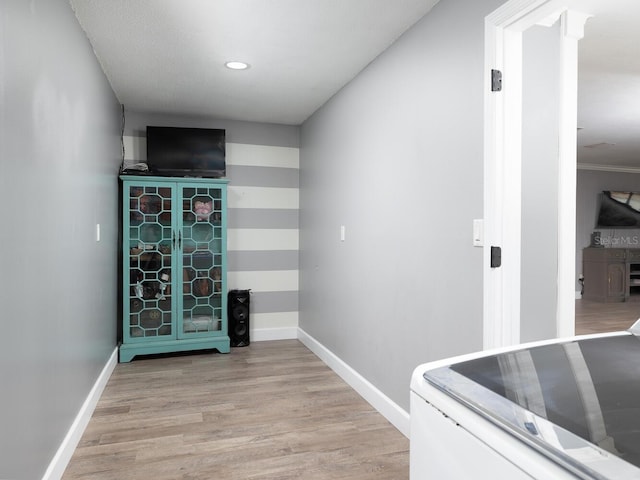 laundry area with washer / clothes dryer, light hardwood / wood-style flooring, and ornate columns