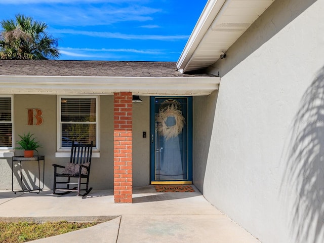 view of exterior entry featuring covered porch