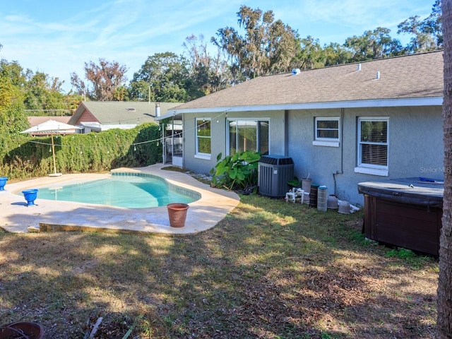 view of pool with a yard and central AC unit