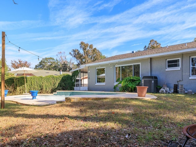 back of house with cooling unit, a patio, and a lawn