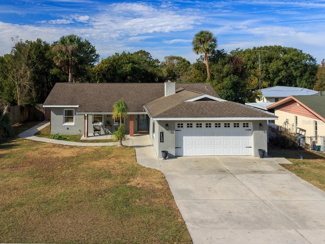 ranch-style home featuring a garage, a front yard, and covered porch