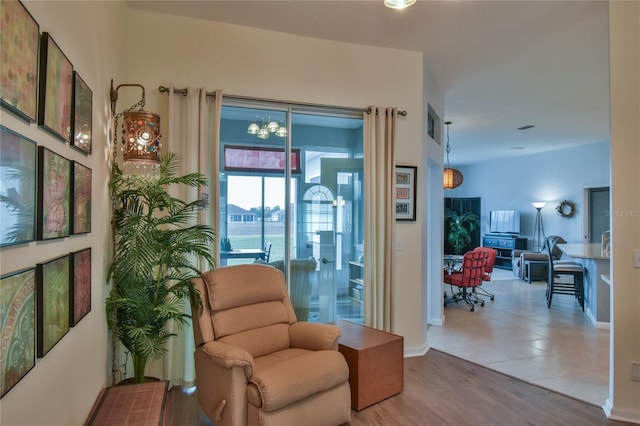 living area with a chandelier and light hardwood / wood-style floors