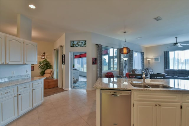 kitchen with white cabinets, sink, hanging light fixtures, stainless steel dishwasher, and light stone countertops