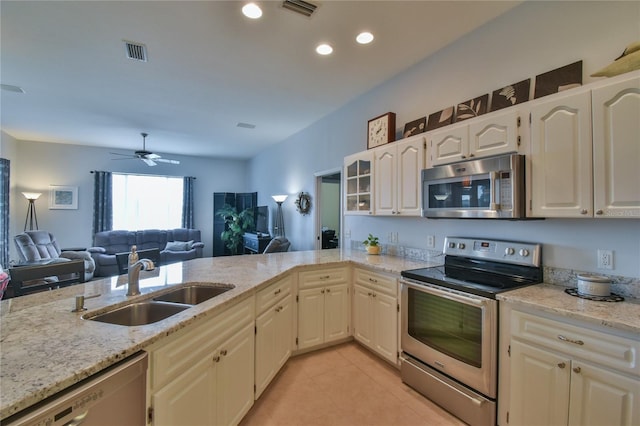 kitchen with white cabinets, sink, ceiling fan, appliances with stainless steel finishes, and light stone counters