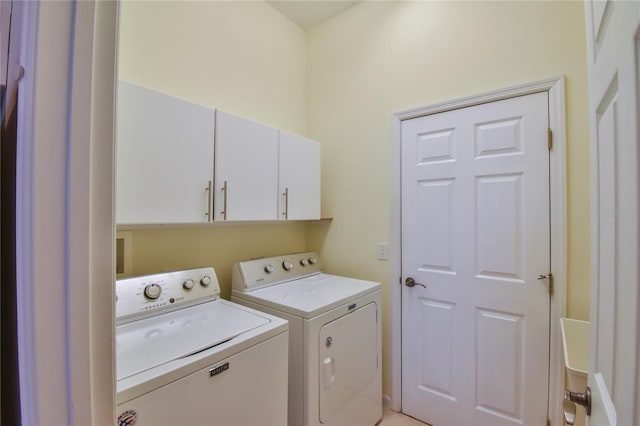 laundry room with washer and dryer and cabinets