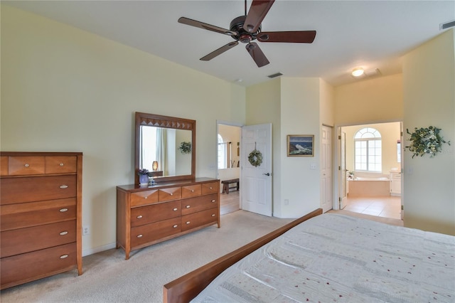 bedroom featuring connected bathroom, ceiling fan, and light colored carpet