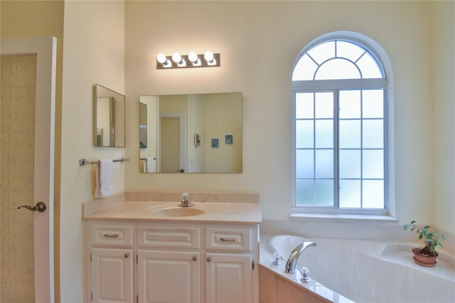 bathroom with a tub, a wealth of natural light, and vanity