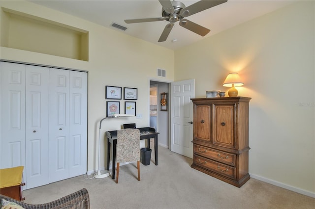 carpeted office space featuring ceiling fan