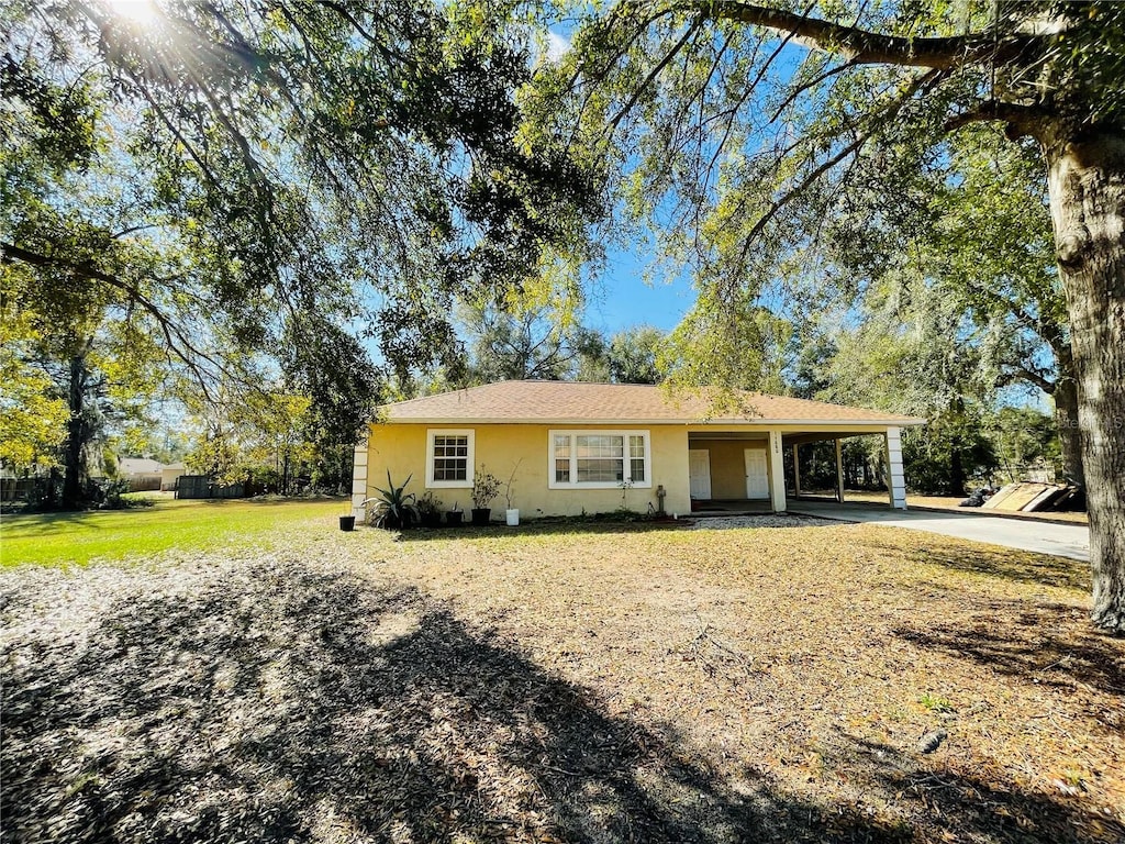 single story home featuring a front lawn and a carport