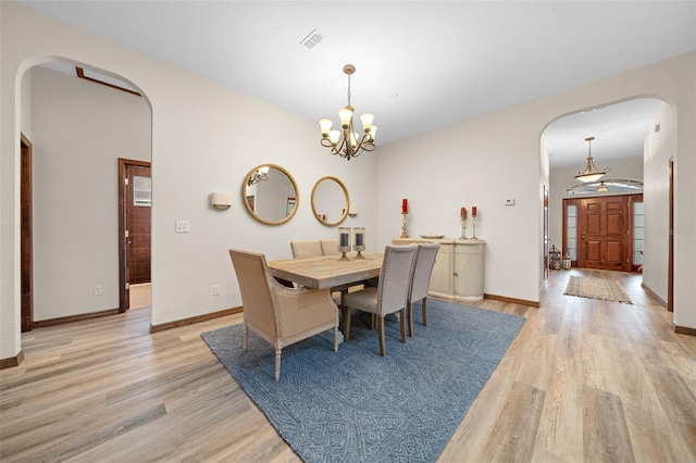 dining room with an inviting chandelier and light hardwood / wood-style flooring