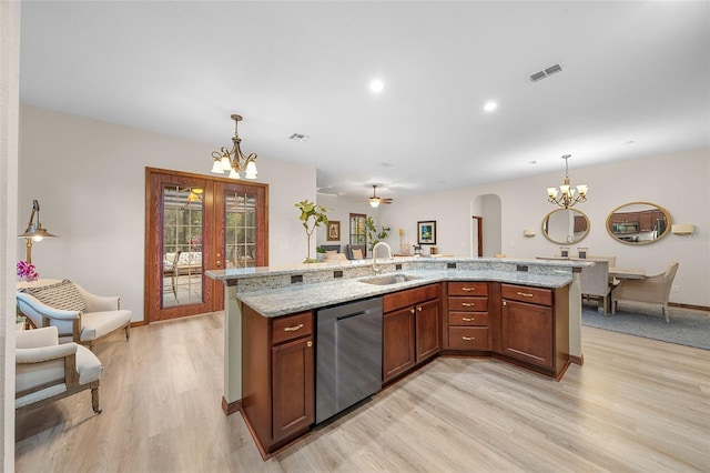 kitchen with dishwasher, sink, light stone counters, a large island with sink, and decorative light fixtures