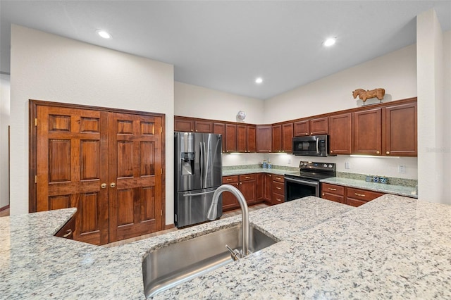 kitchen featuring light stone counters, sink, and appliances with stainless steel finishes