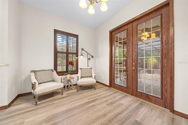 sitting room featuring a chandelier, french doors, and light hardwood / wood-style floors