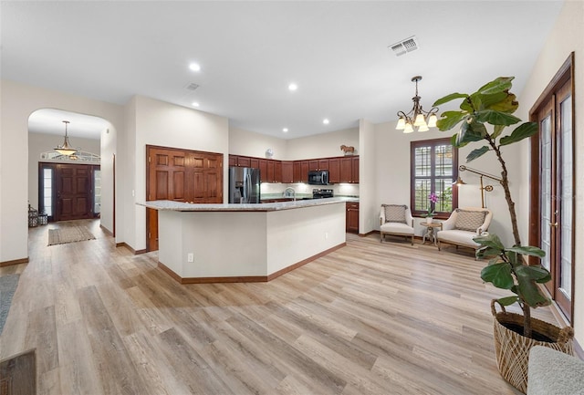 kitchen with a chandelier, pendant lighting, light hardwood / wood-style flooring, and black appliances