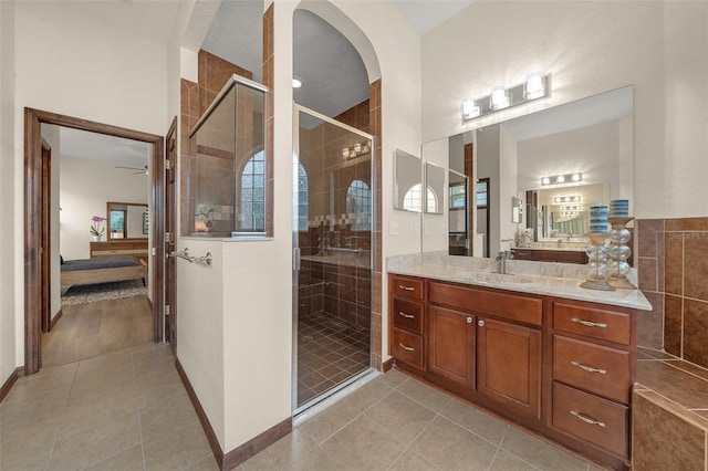 bathroom with tile patterned floors, vanity, ceiling fan, and a shower with shower door