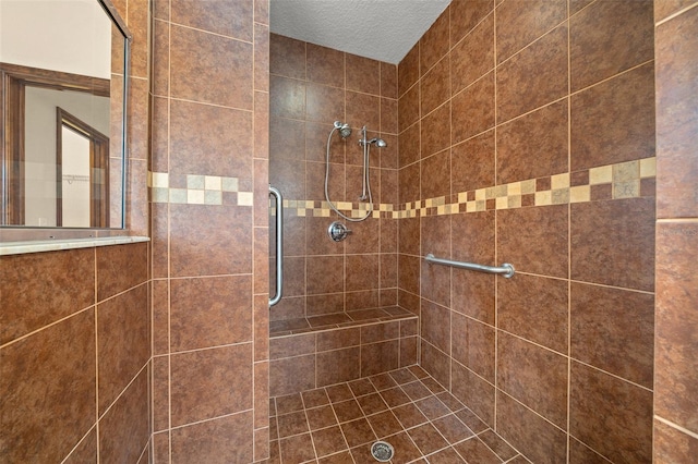 bathroom with a tile shower and a textured ceiling