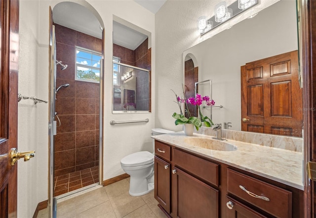 bathroom with tile patterned floors, vanity, toilet, and an enclosed shower