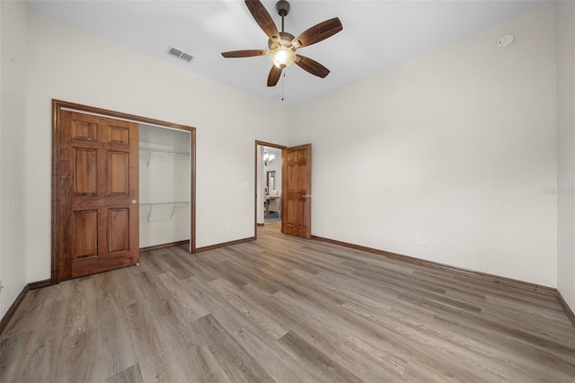 unfurnished bedroom with ceiling fan, a closet, and light wood-type flooring