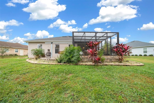 rear view of house featuring a lanai and a lawn