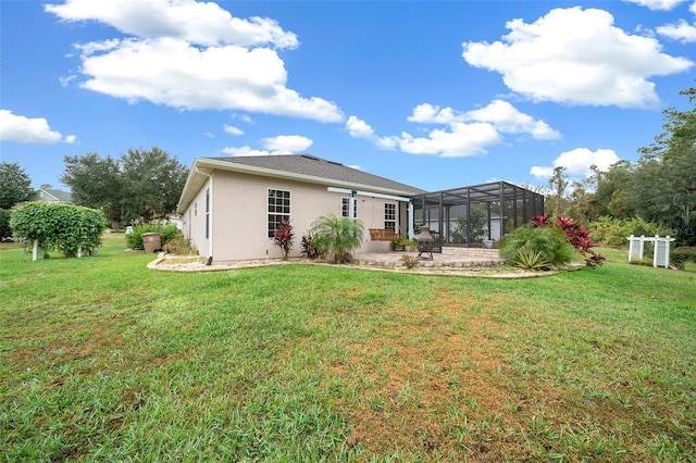 rear view of house with a lawn, a lanai, and a patio