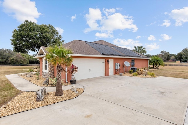 view of front of home featuring central AC unit, solar panels, a garage, and a front lawn