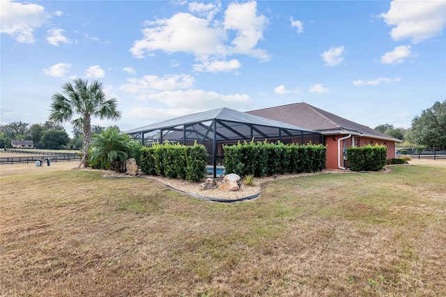 view of yard with a lanai and a rural view