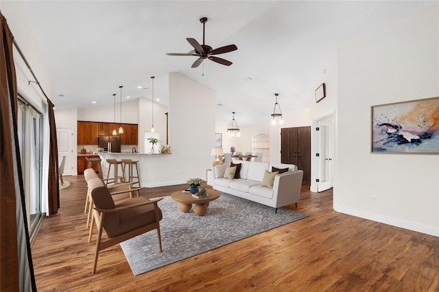 living room featuring ceiling fan, dark wood-type flooring, and high vaulted ceiling