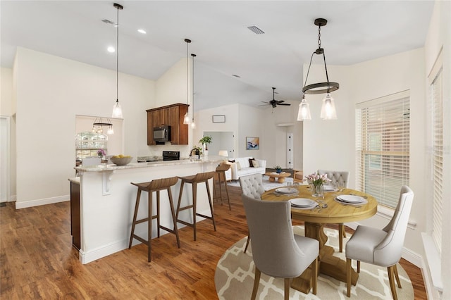 dining space featuring ceiling fan, dark hardwood / wood-style floors, and high vaulted ceiling