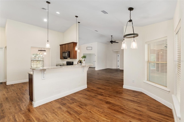 kitchen with a kitchen breakfast bar, vaulted ceiling, ceiling fan, dark hardwood / wood-style flooring, and kitchen peninsula