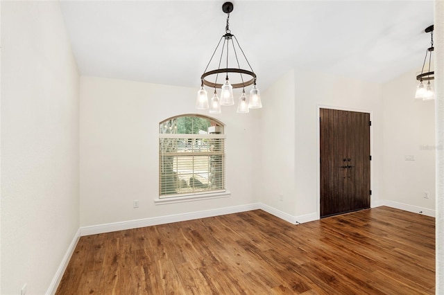 unfurnished room featuring hardwood / wood-style floors and an inviting chandelier