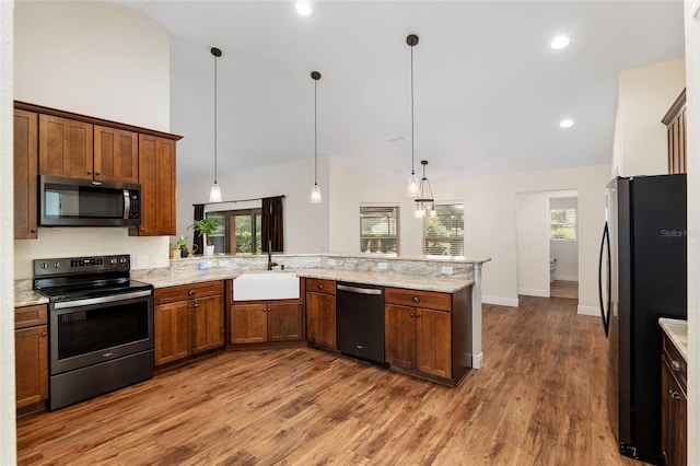 kitchen with sink, hardwood / wood-style flooring, decorative light fixtures, kitchen peninsula, and stainless steel appliances