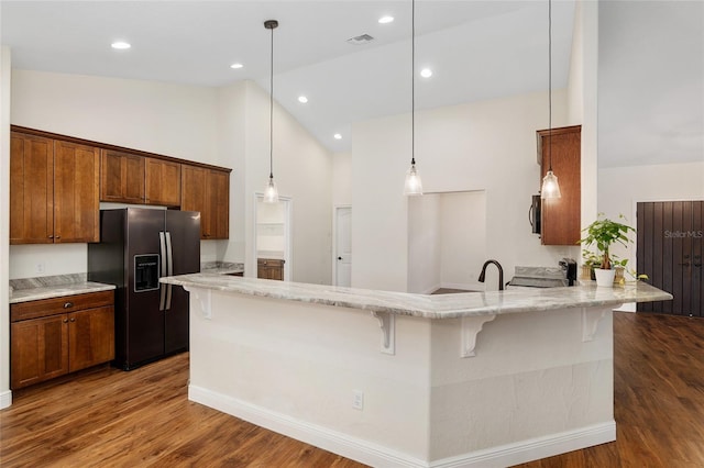 kitchen with kitchen peninsula, appliances with stainless steel finishes, dark hardwood / wood-style flooring, and high vaulted ceiling