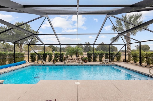 view of swimming pool with glass enclosure and a patio area