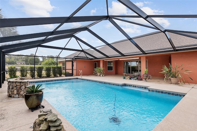 view of swimming pool featuring a patio area and a lanai