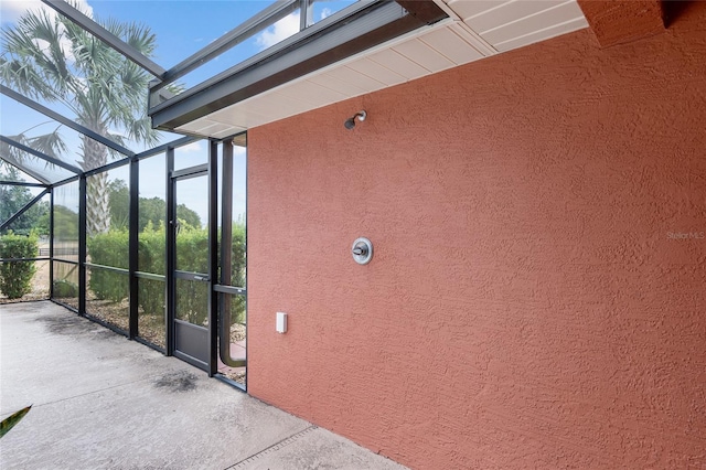 view of side of property featuring glass enclosure