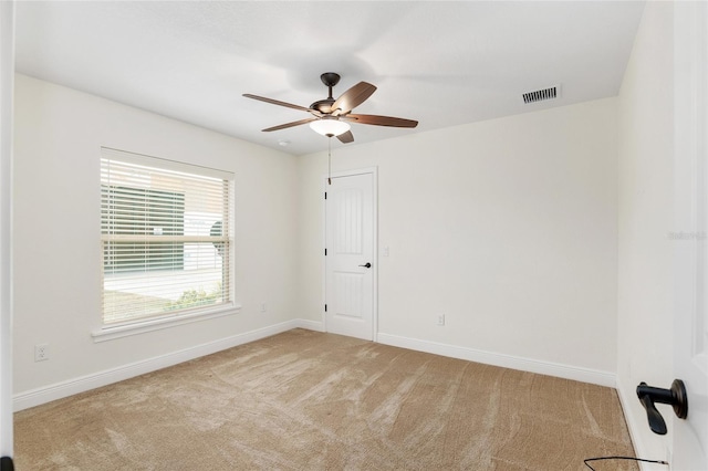 carpeted spare room with ceiling fan