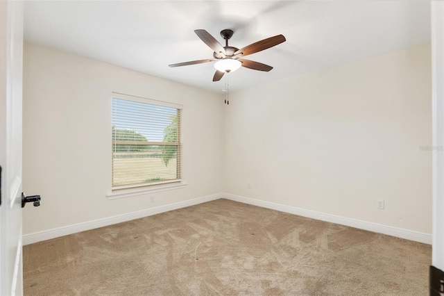 spare room with light colored carpet and ceiling fan