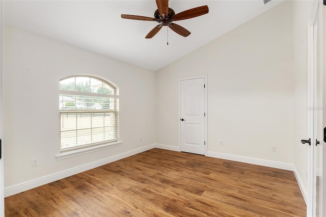 empty room featuring hardwood / wood-style flooring, ceiling fan, and vaulted ceiling