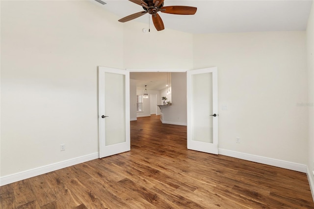 empty room featuring ceiling fan, french doors, high vaulted ceiling, and wood-type flooring